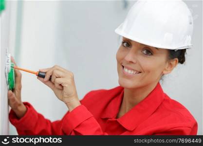 a woman electrician fixing socket