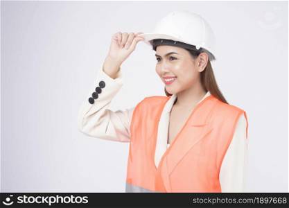 a woman engineer wearing a protective helmet over white background studio