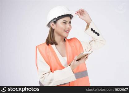 a woman engineer wearinng a protective helmet over white backgroud studio
