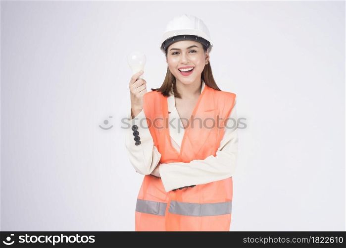 a woman engineer wearinng a protective helmet over white backgroud studio