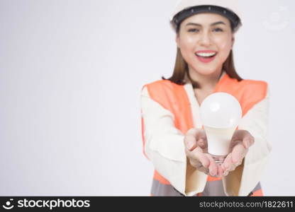 a woman engineer wearinng a protective helmet over white backgroud studio