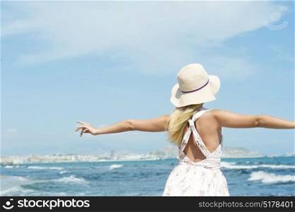 A woman enjoys the summer breeze at a seaside town