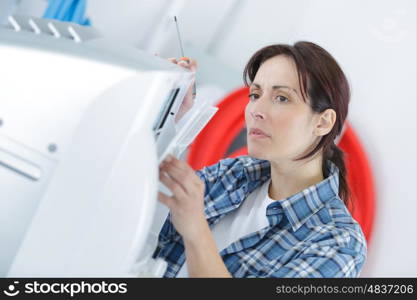 a woman fixing a printer at office