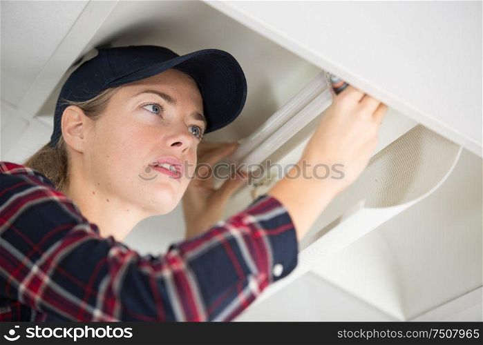 a woman fixing kitchen furniture