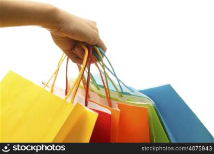 A woman hand carrying a bunch of colorful shopping bags
