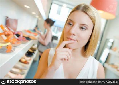 a woman hesitating in shoeshop