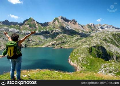 a woman hiker looking at Lake Estaens in the Pyrenees mountains