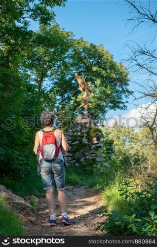a woman hiker on mountain trail, back view