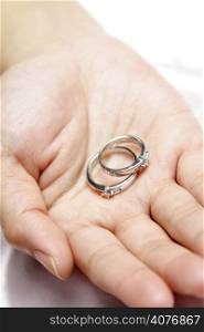 A woman holding a pair of wedding rings