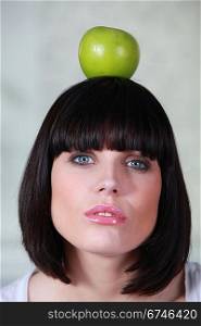a woman holding an apple on her head