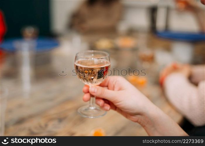 A woman holds a glass of champagne in her hand.. A glass of champagne in a womans hand at the table 4280.