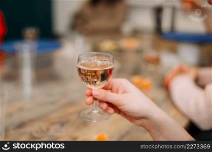 A woman holds a glass of champagne in her hand.. A glass of champagne in a womans hand at the table 4280.