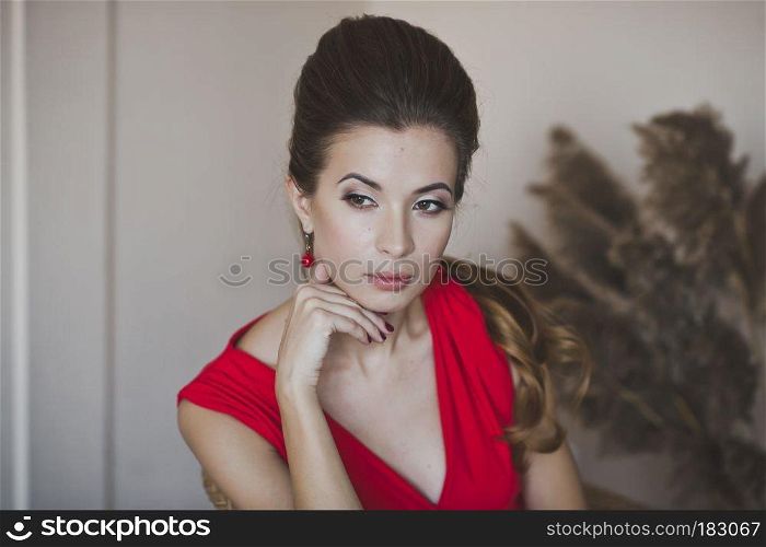 A woman in a long red dress.. Pensive girl sitting in a chair 4922.