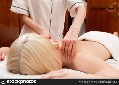 A woman in a retro styled spa receiving a shoulder massage