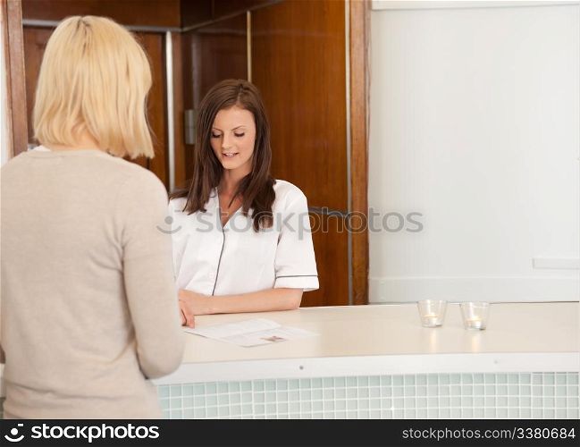 A woman in a spa recpetion deciding on a treatment