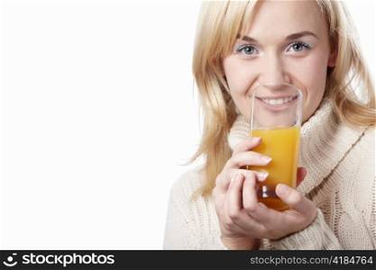 A woman in a sweater drinking juice on a white background