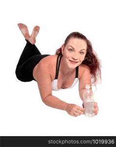 A woman in exercise outfit lying on the floor on her stomach and holding a water bottle in her hand, isolated for white background