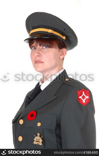 A woman in her forties in a dark green military uniform with a cap onstanding for white background for a portrait.