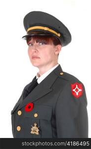 A woman in her forties in a dark green military uniform with a cap onstanding for white background for a portrait.