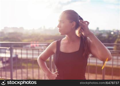 A woman in sportswear doing fitness exercises. City in sunny evening.. Modern fitness life