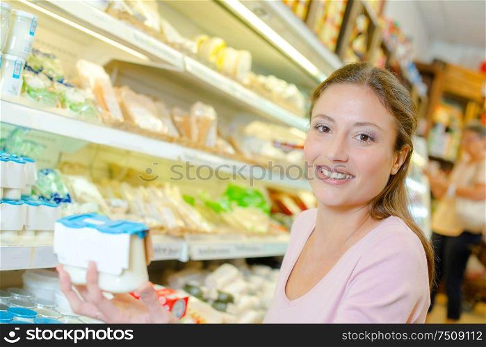 a woman is buying yoghurt