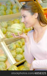 a woman is choosing melons