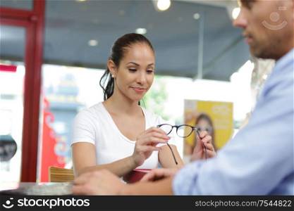 a woman is chosing glasses