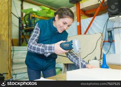 a woman is cutting wood