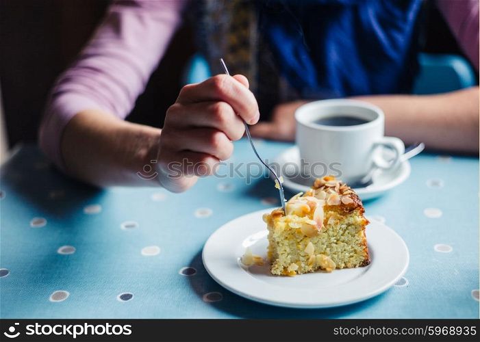 A woman is having coffee and cake in a tearoom