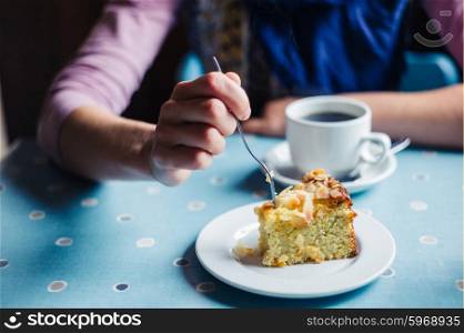 A woman is having coffee and cake in a tearoom