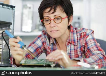 a woman is soldering a pc