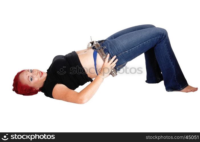 A woman lying on the floor trying to pull up her jeans, with red hair,isolated for white background.