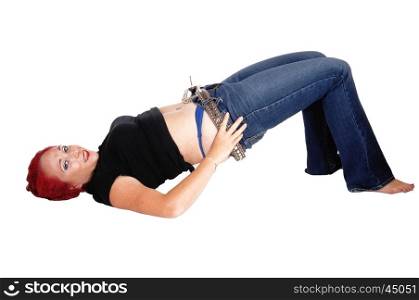 A woman lying on the floor trying to pull up her jeans, with red hair,isolated for white background.
