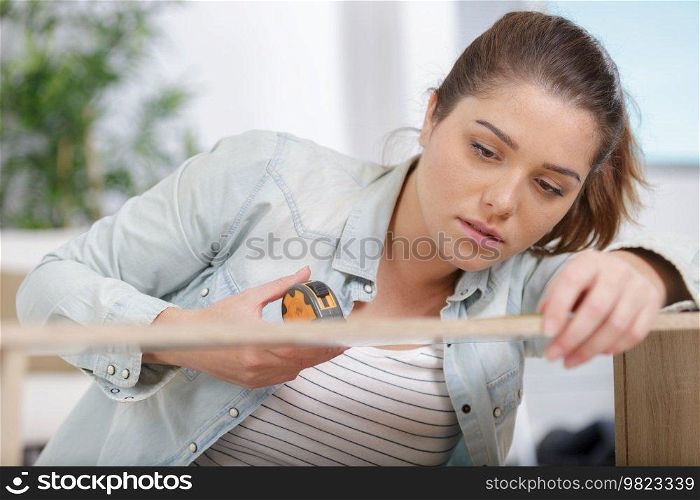 a woman measuring a furniture
