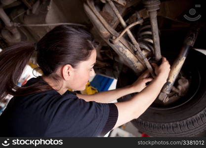 A woman mechanic working on a car, checking a cv boot