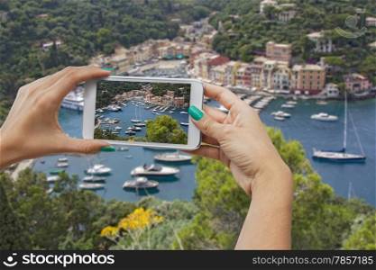 A woman photographing with mobile phone, Portofino, Cinque Terre, Italy