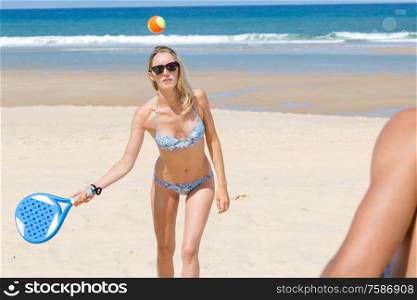 a woman playing beach tennis