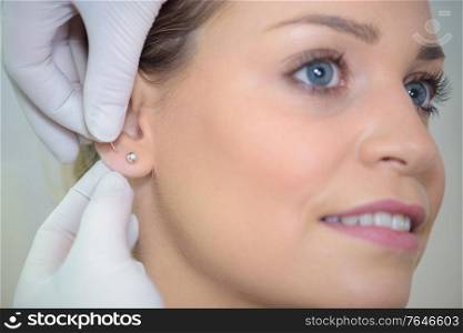 a woman putting an extra earrings