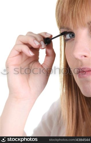 a woman putting mascara