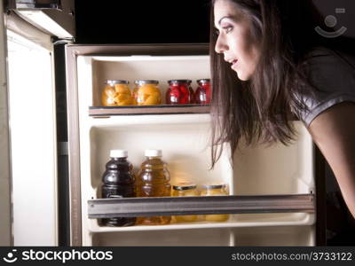 A woman raids the refrigerator late at night