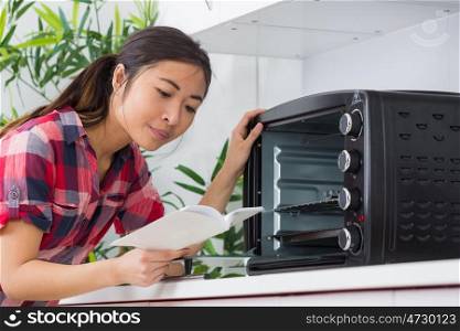 a woman reading the oven manual