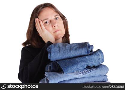 A woman rests her head on her hand while holding a pile of folded clothes