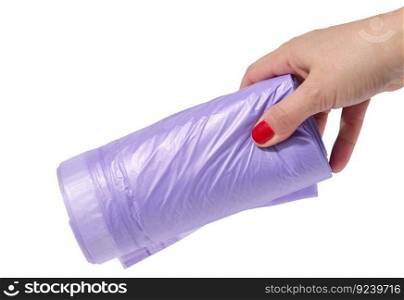 A woman&rsquo;s hand holds a roll of plastic bags for the trash can on a white isolated background