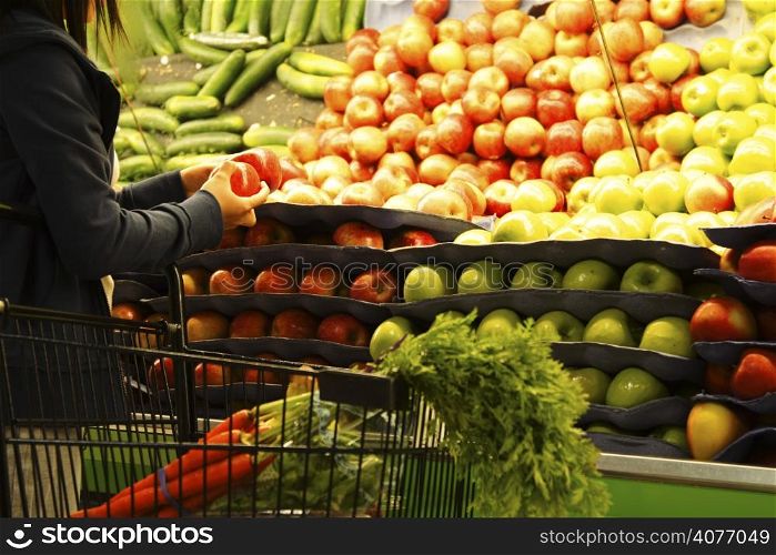 A woman shopping for apples at a grocery store or supermarket