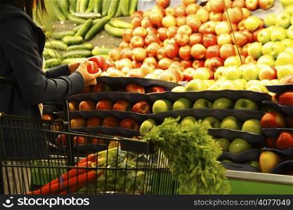 A woman shopping for apples at a grocery store or supermarket