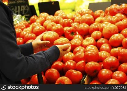 A woman shopping for tomatoes at the supermarket