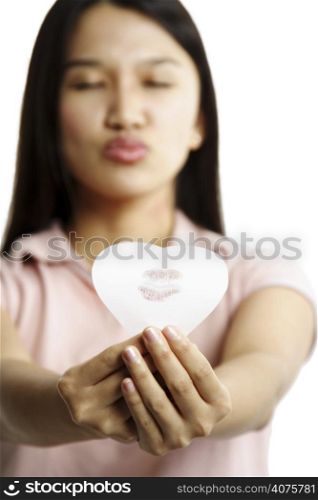 A woman showing a heart shaped paper with her kiss mark
