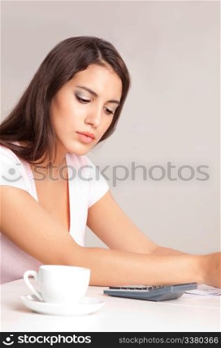A woman sitting at a desk calculating finances