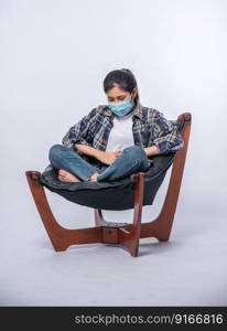 A woman sitting in a chair with abdominal pain and pressing her hand on her stomach