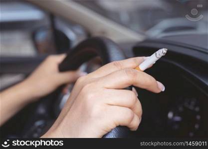 A woman smoking in a car